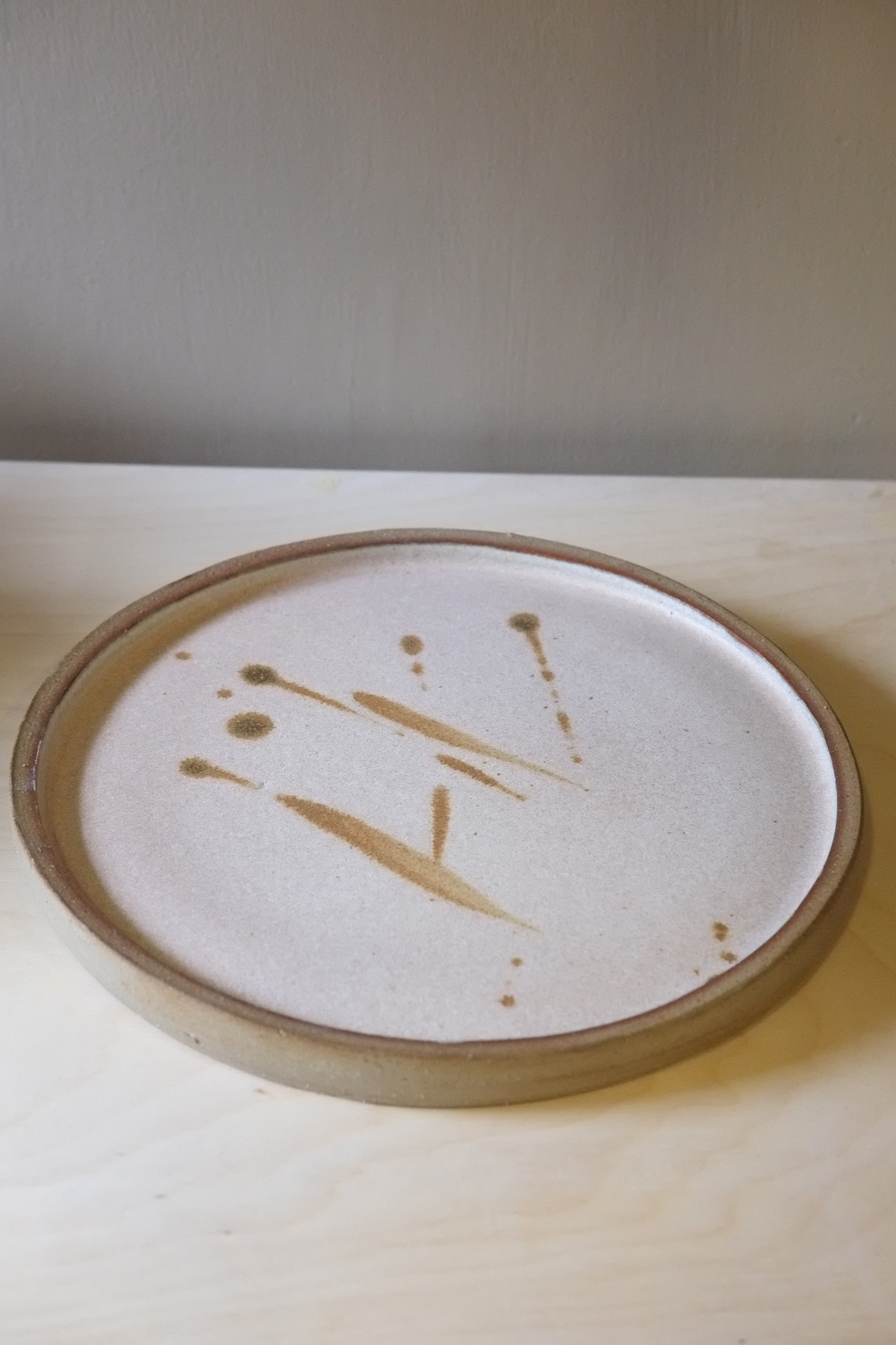 Round ceramic plate with abstract design on a plain background