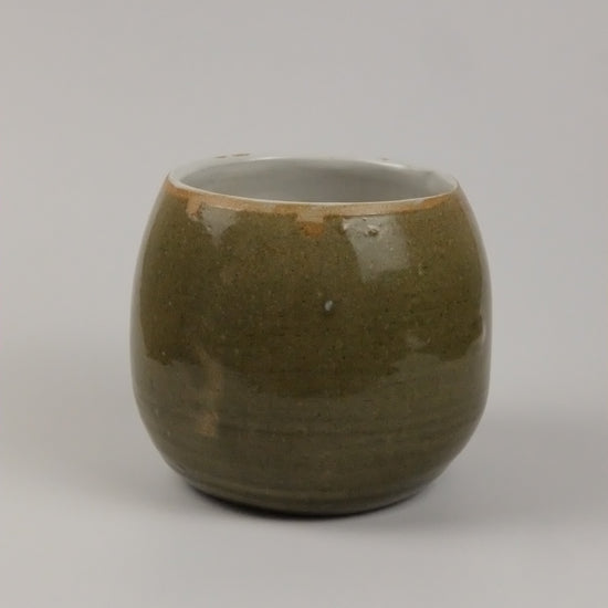 A green vase on a white background 