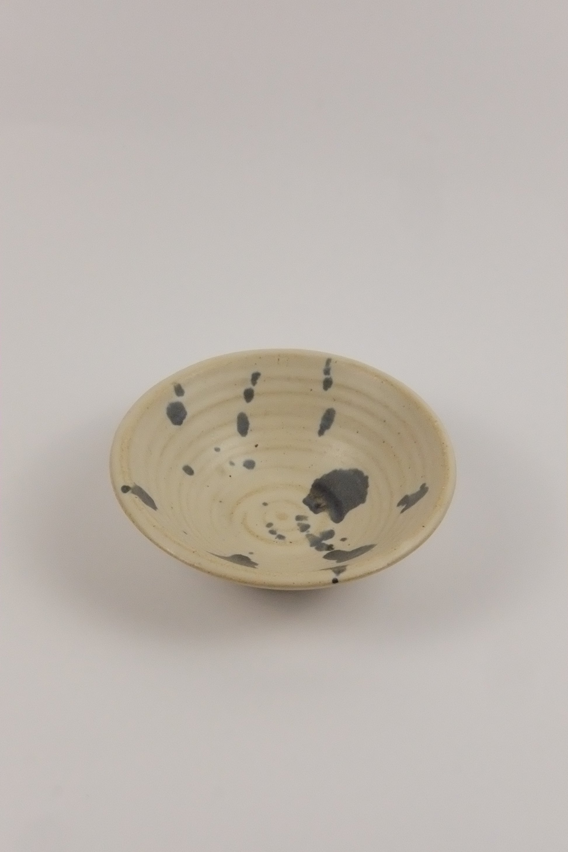 Ceramic plate with speckled design on a plain background
