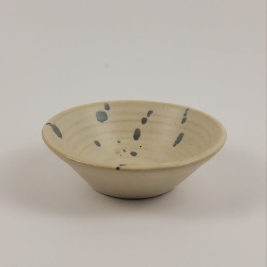 Ceramic wall hook with speckled design on a plain background