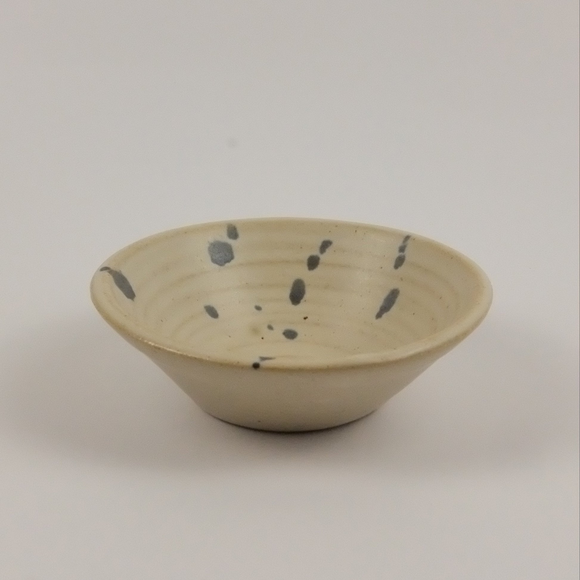 Ceramic wall hook with speckled design on a plain background