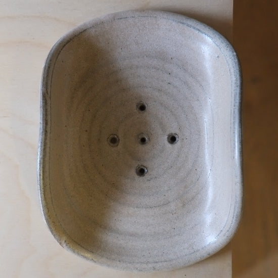 Ceramic incense holder with circular design on a wooden surface