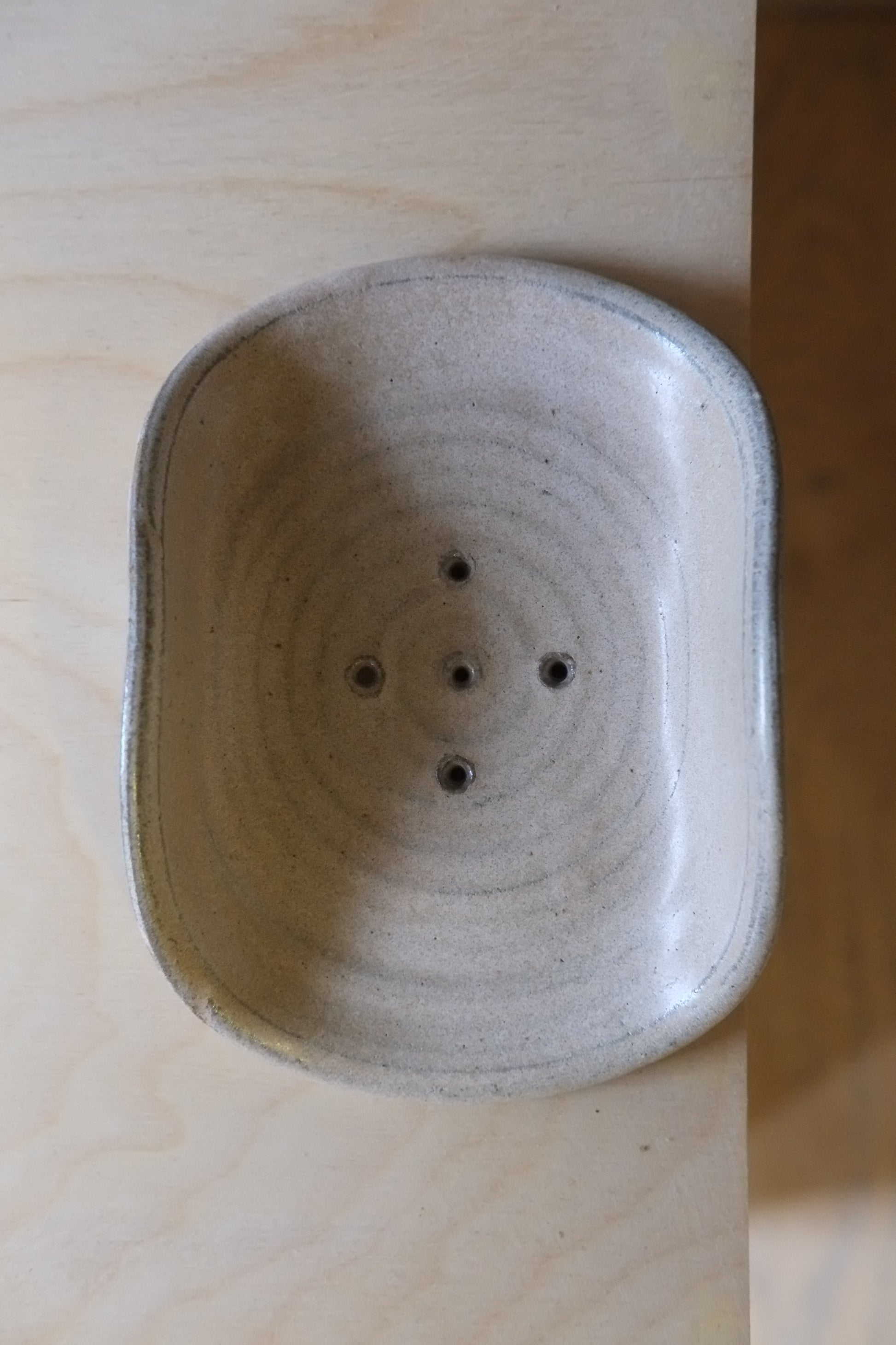 Ceramic incense holder with circular design on a wooden surface