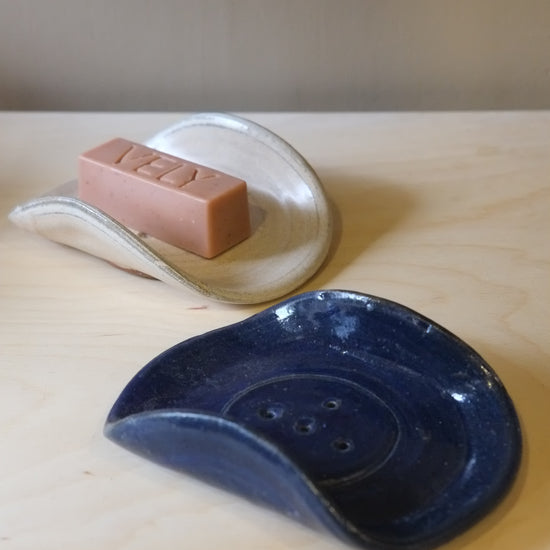 Blue ceramic dish and pink soap on a wooden surface