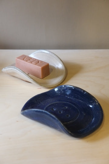 Blue ceramic dish and pink soap on a wooden surface