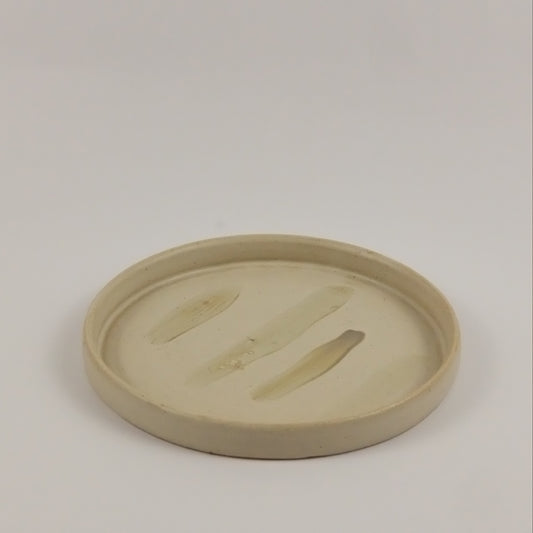 Round beige object on a light gray background