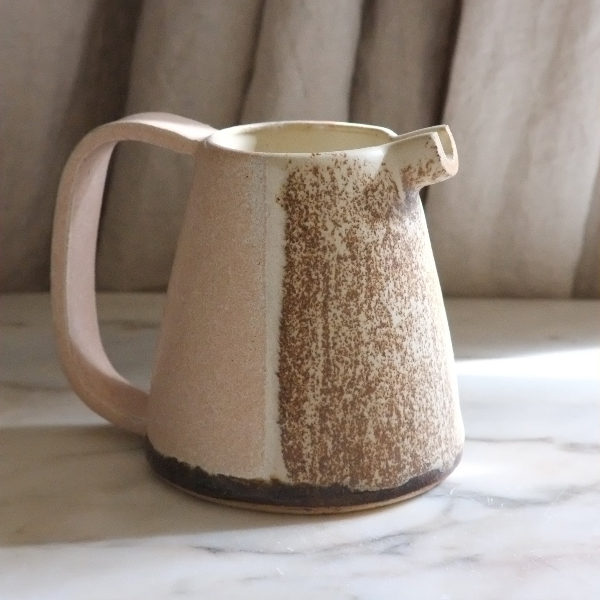 a ceramic jug on a marble table 
