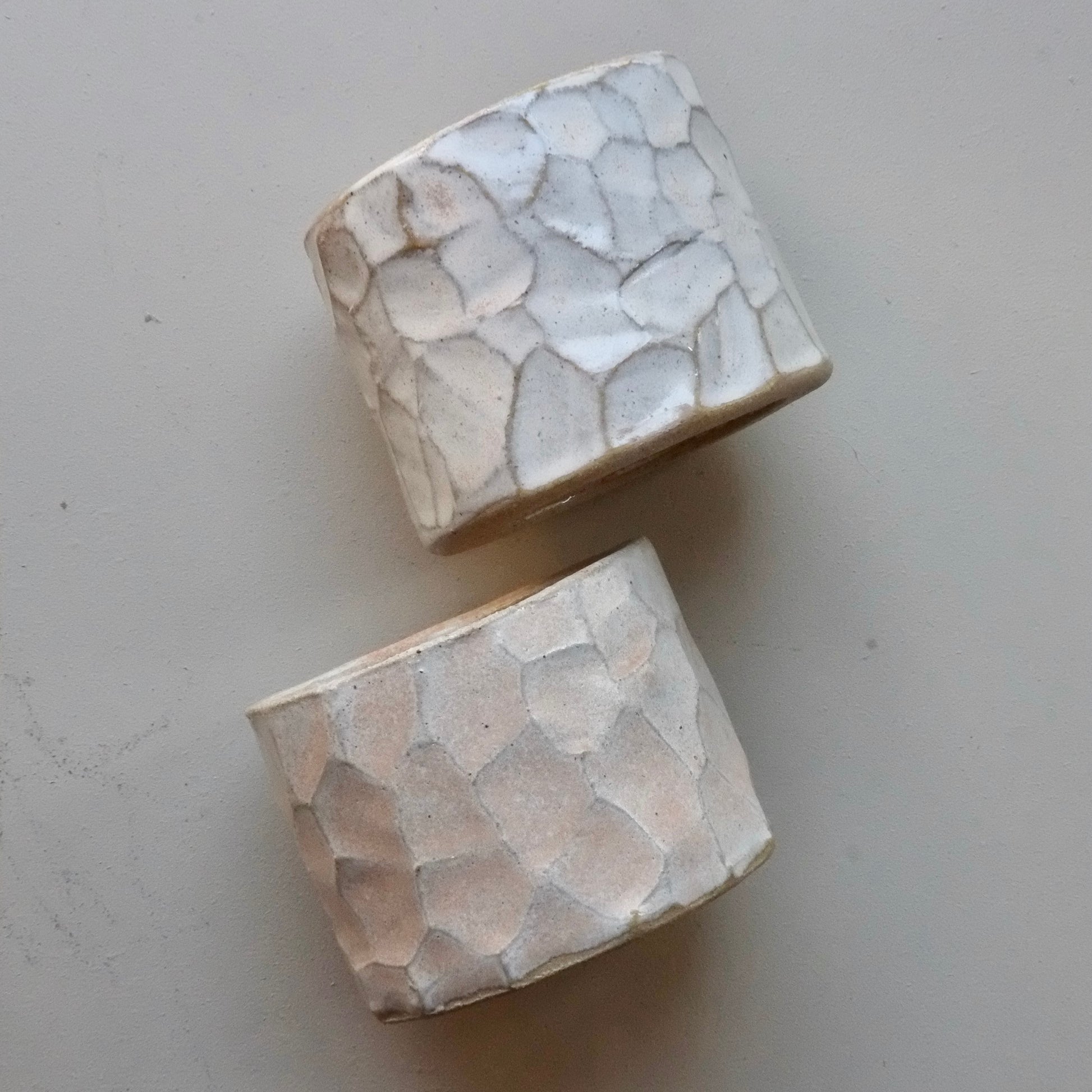 two ceramic pots on a gray background