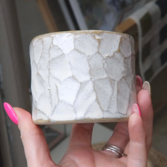 someone holding a white pot on a natural background 