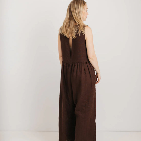 Woman wearing a brown jumpsuit against a white background