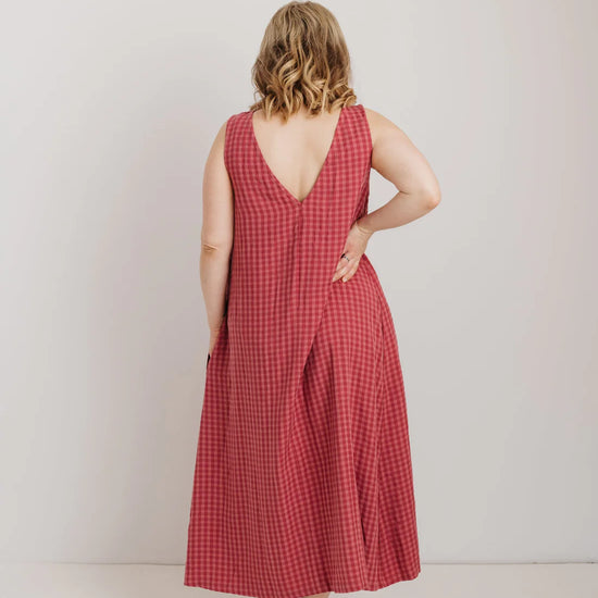 Woman wearing a pink checkered dress against a white background