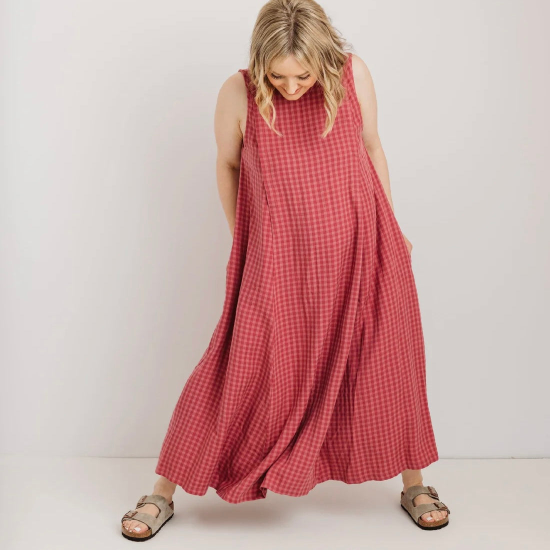 Woman wearing a pink checkered dress against a white background