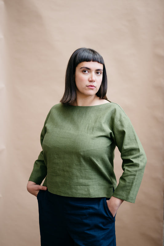 Woman wearing a green sweater against a beige background