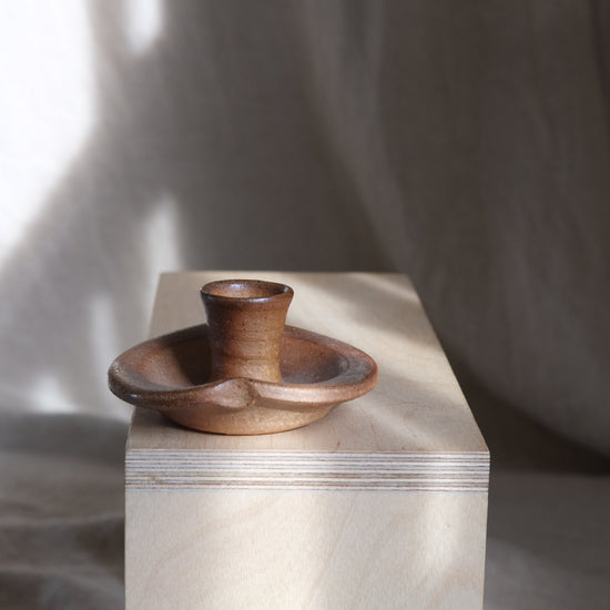 Wooden candle holder on a marble block with a soft background
