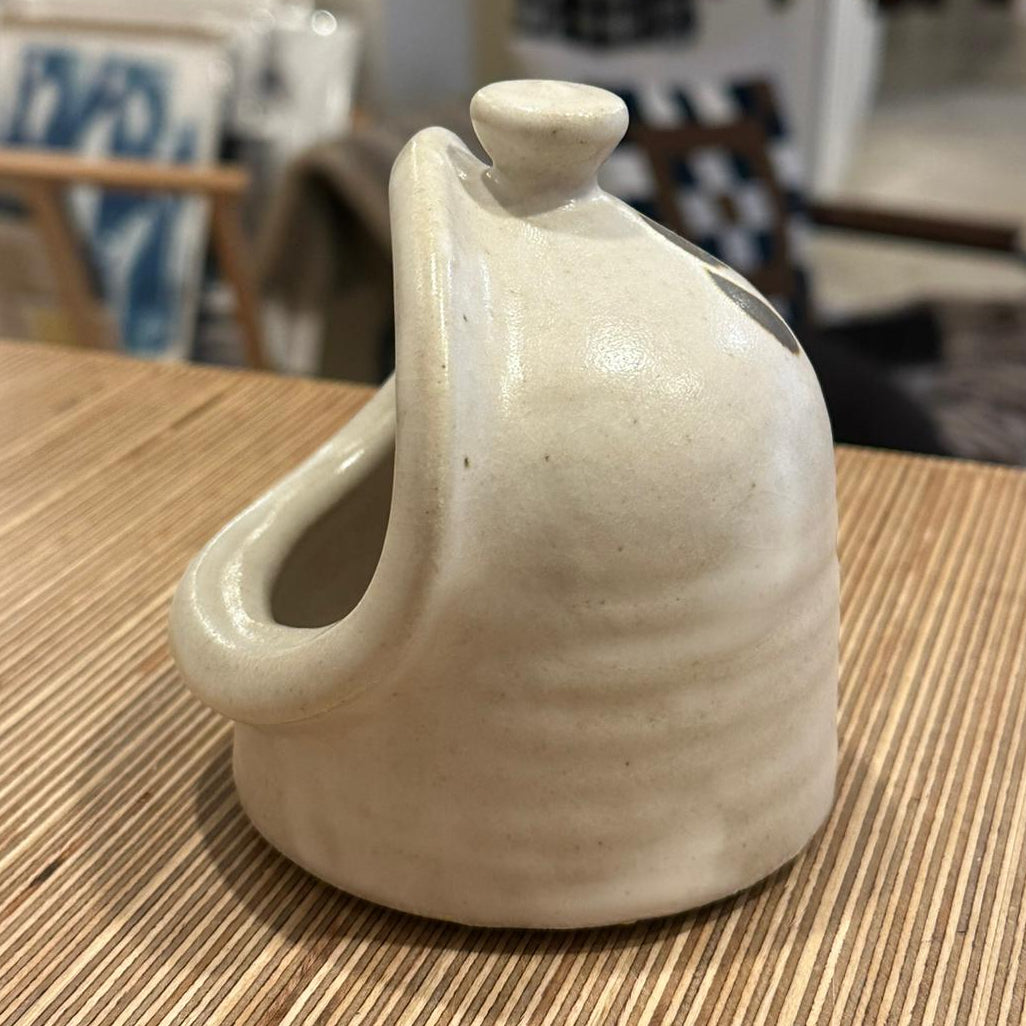 A white salt pig on a wooden surface 