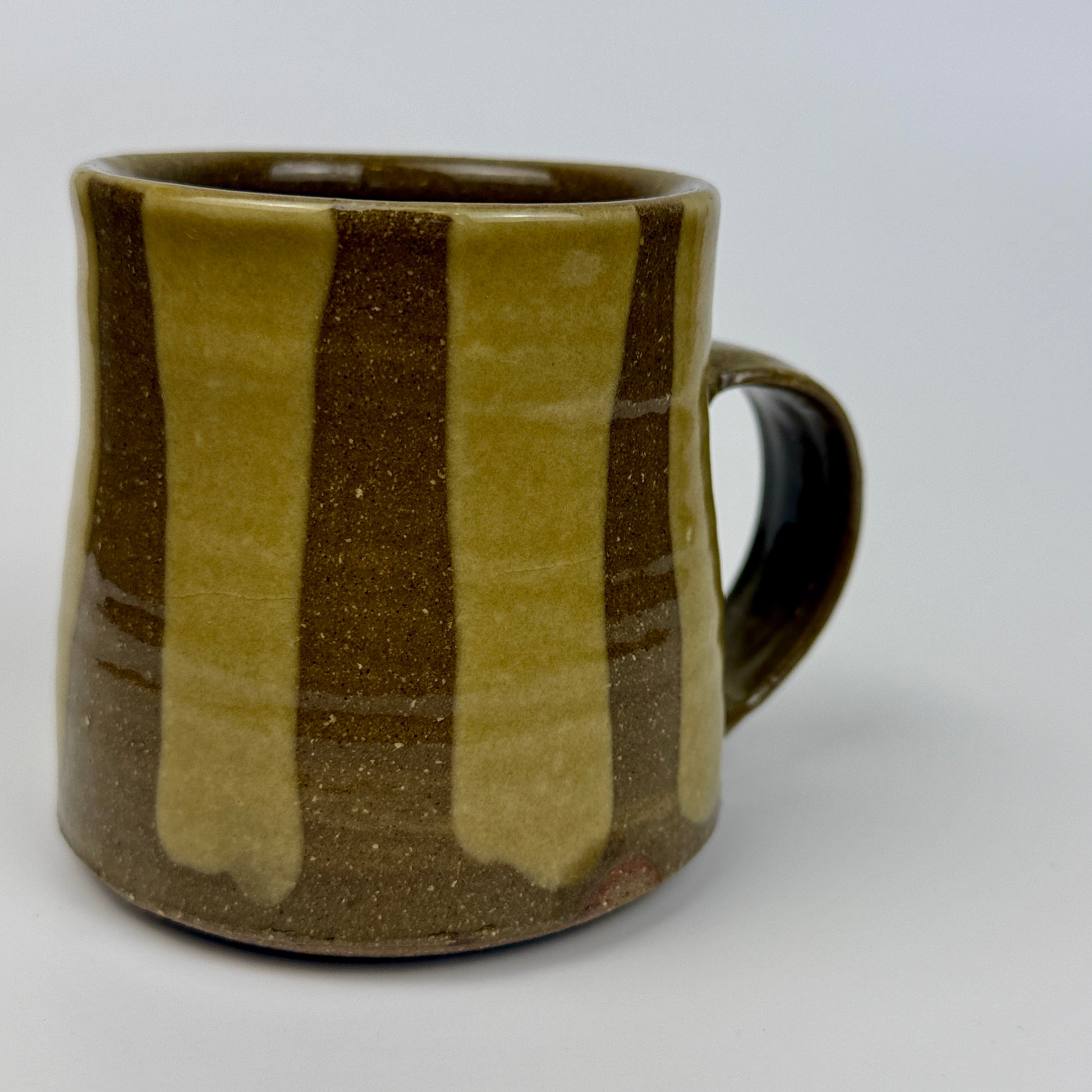 Brown and green striped ceramic mug on a white background