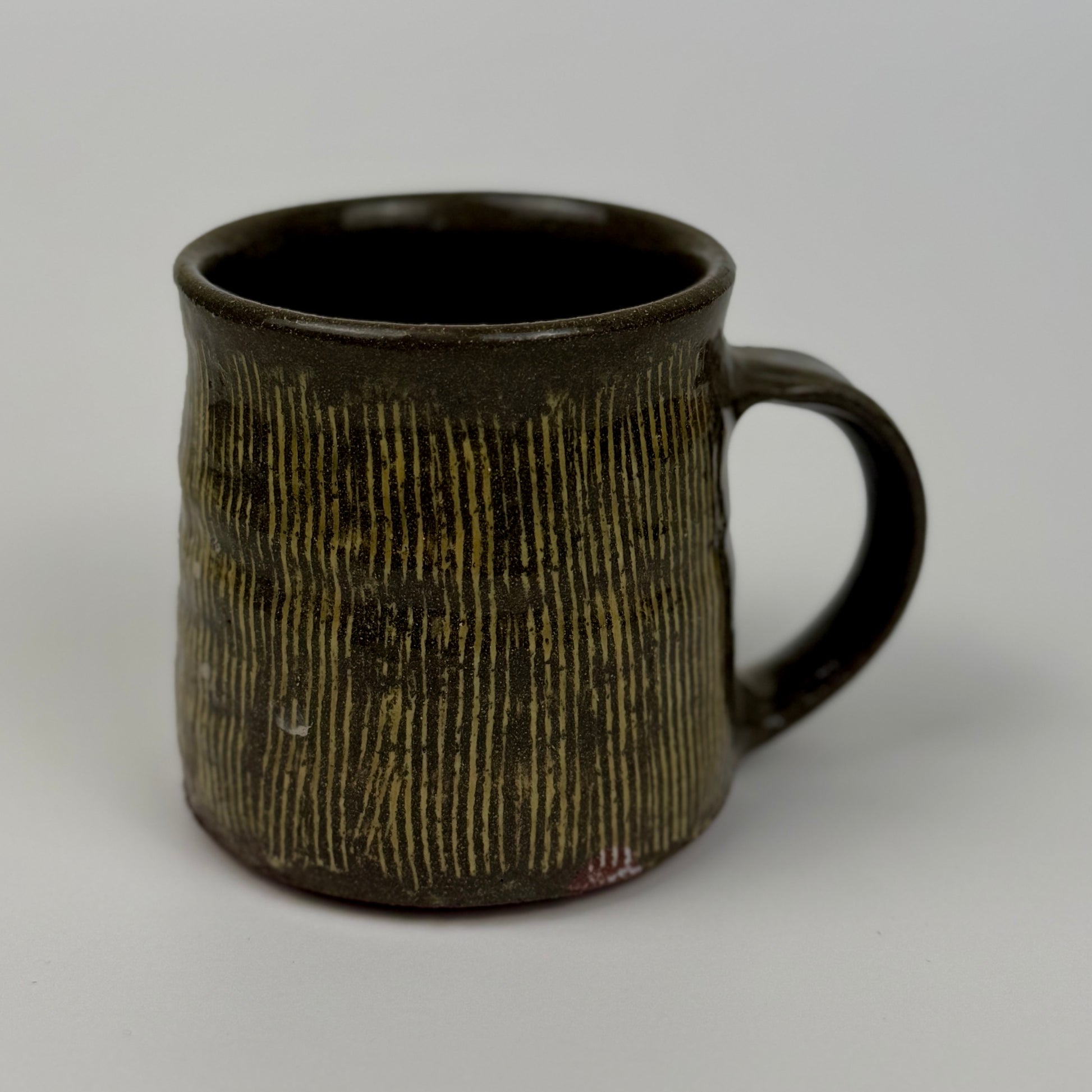 Brown ceramic mug with textured surface on a gray background