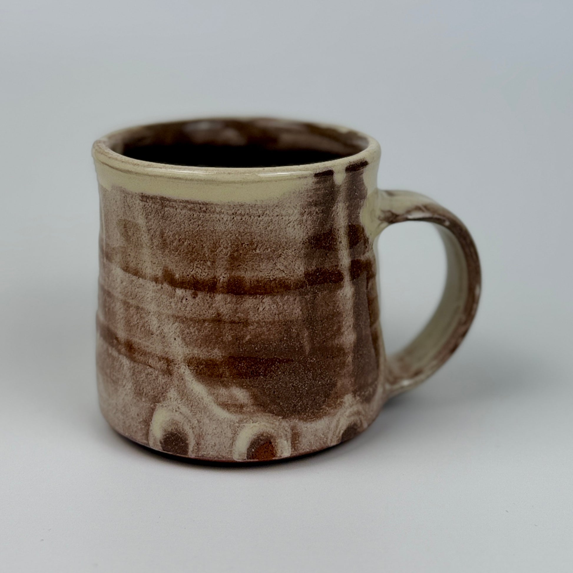 Ceramic mug with brown and beige pattern on a gray background