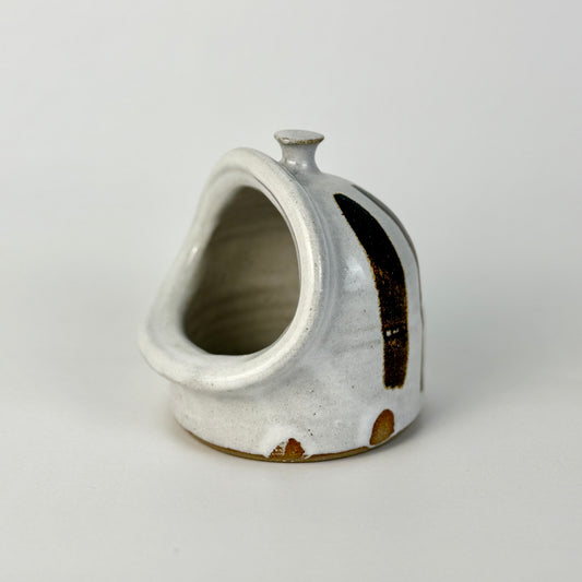 Ceramic teardrop-shaped vase with a textured surface on a light gray background