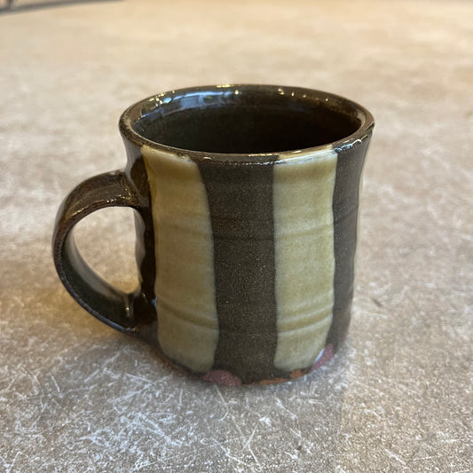A striped mug on a beige background 