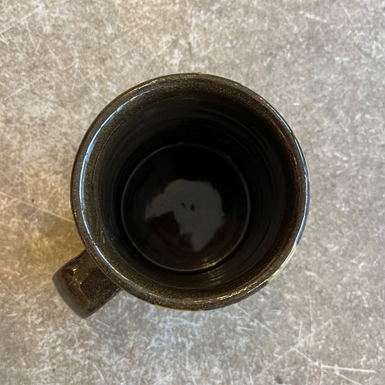 The inside of a brown mug on a beige background 