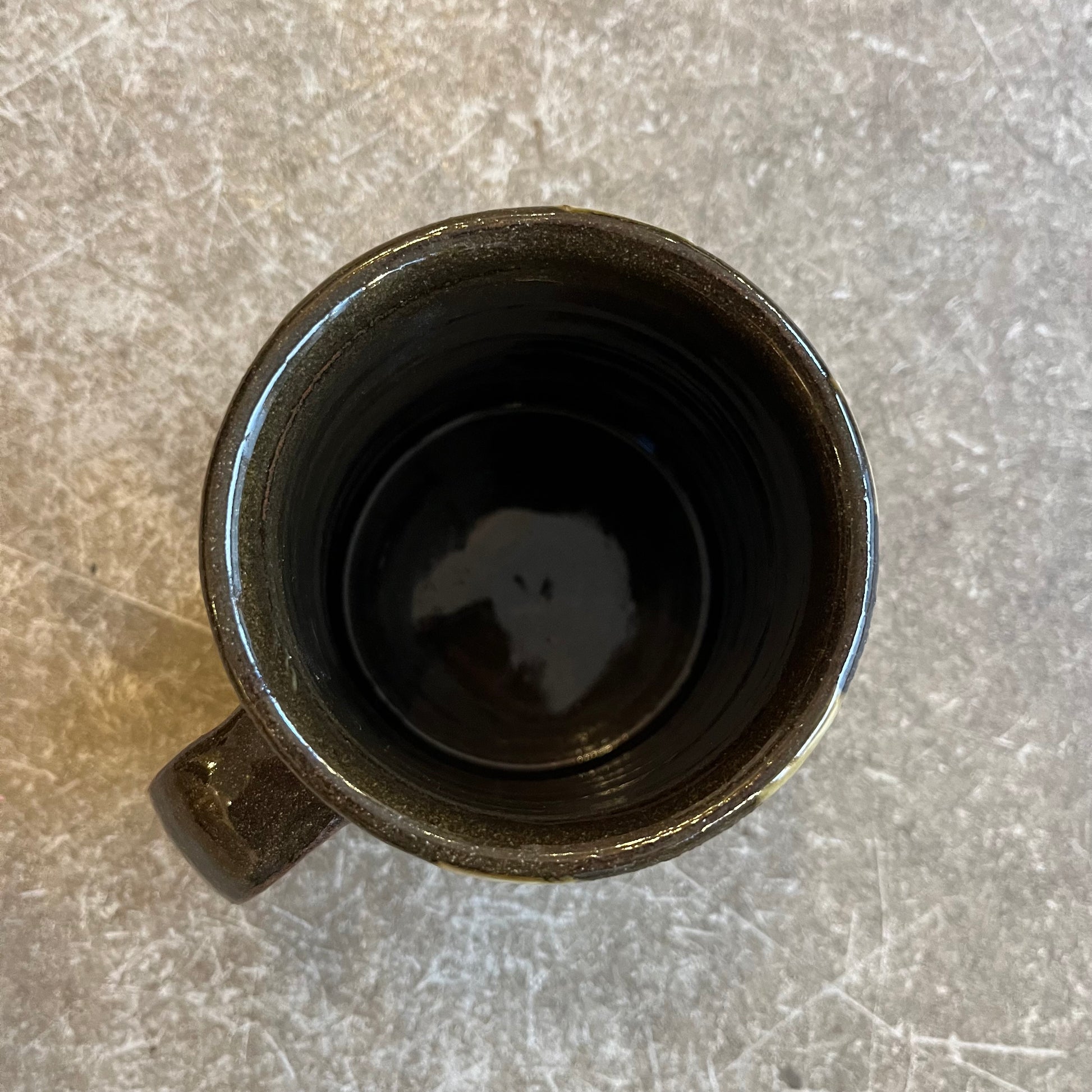 The inside of a brown mug on a beige background 