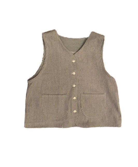 A sleeveless ribbed blue and white stripe colour, featuring a button-down front and two front patch pockets, shown flat on a white background.