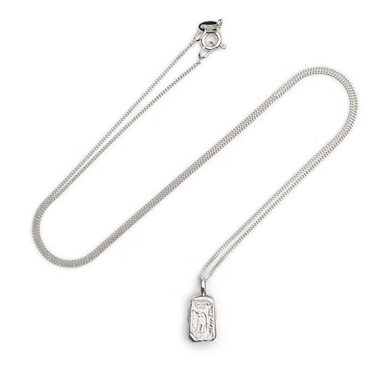 A silver  chain necklace with a small rectangular pendant featuring an embossed figure, displayed on a clean white background.