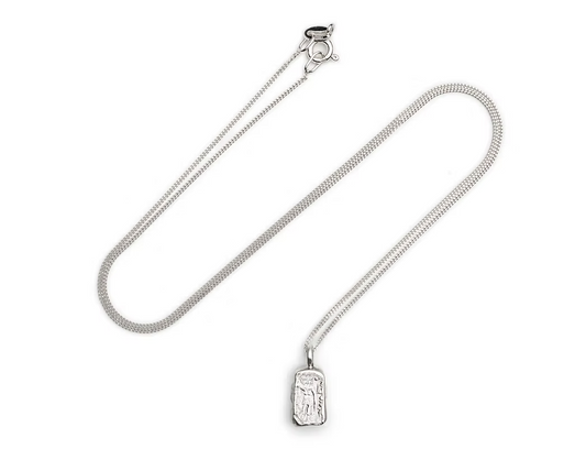 A silver  chain necklace with a small rectangular pendant featuring an embossed figure, displayed on a clean white background.