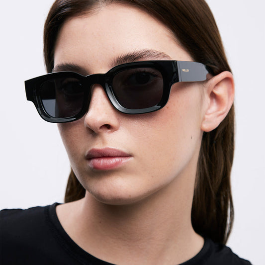 woman wearing dark sunglasses on a white background 