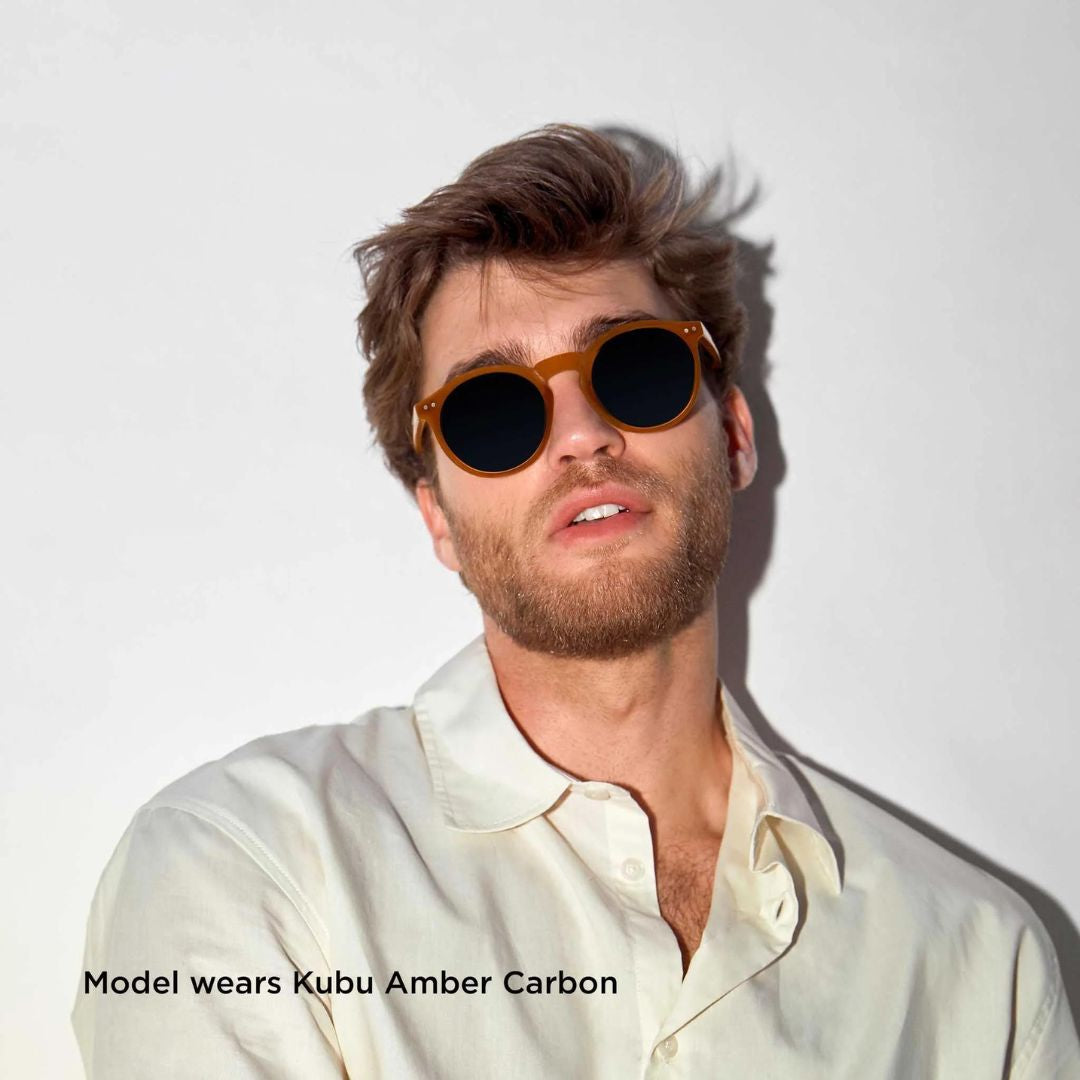 Man wearing sunglasses with 'Model wears Kubu Amber Carbon' text on a white background