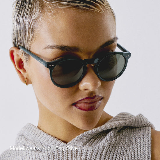 Person wearing dark sunglasses with a neutral background