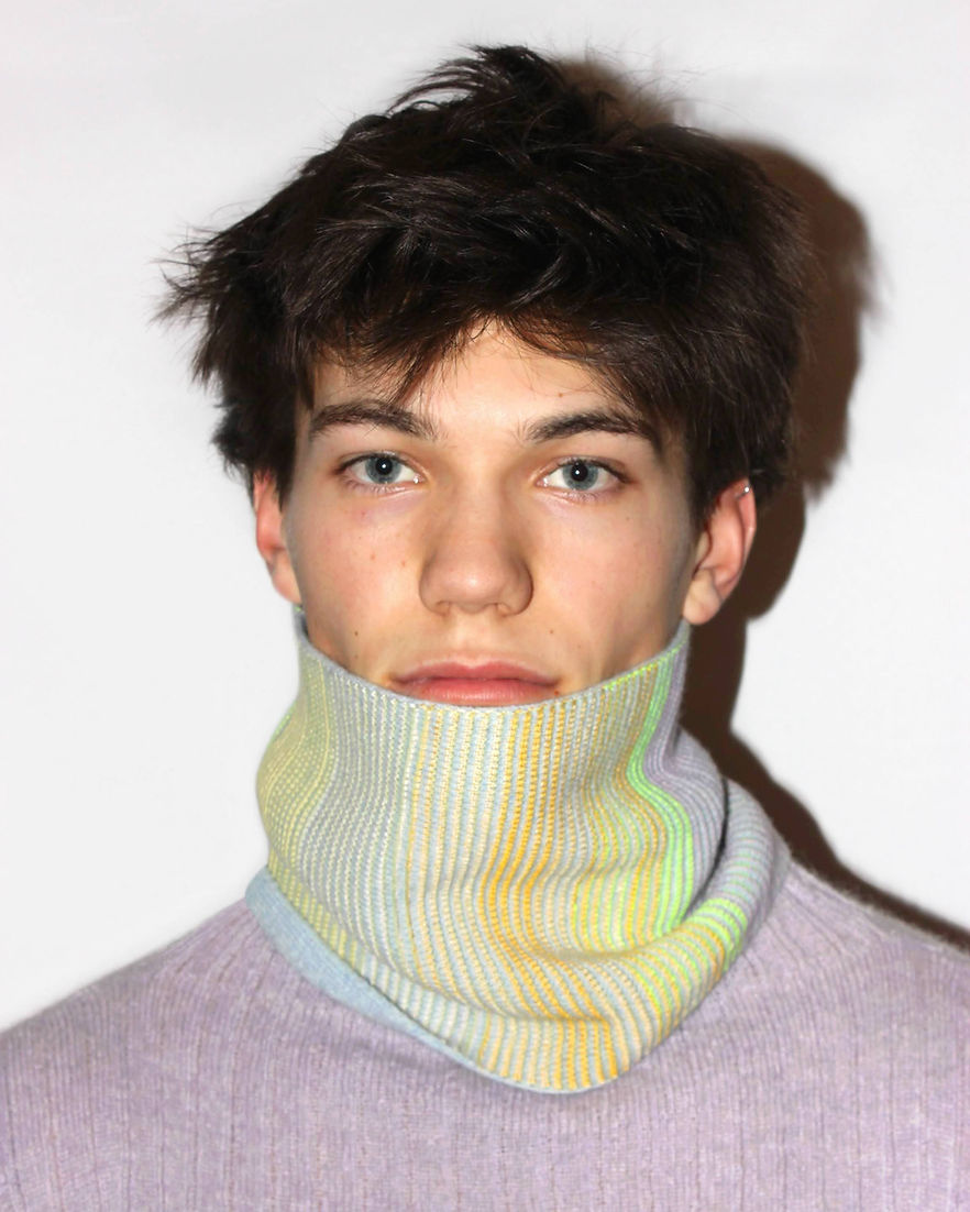 A man wearing a cowl in pale colours 