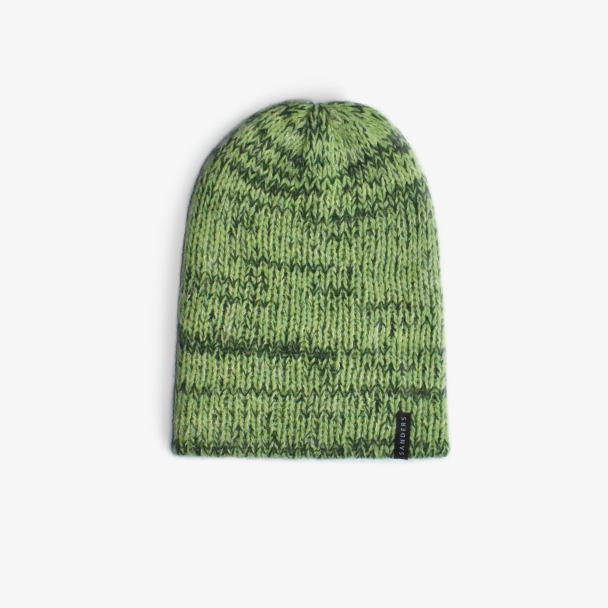 A wooly hat in hues of green on a white background 