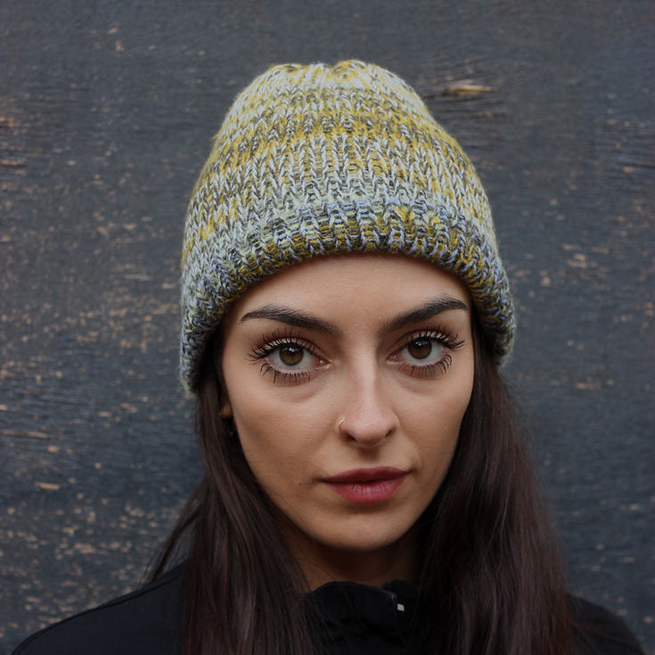 Woman wearing a knitted hat on a charcoal background 