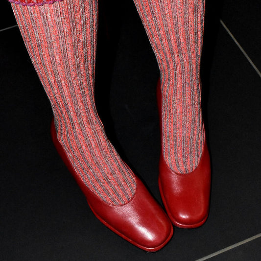 Red and pink socks with red shoes on a black background