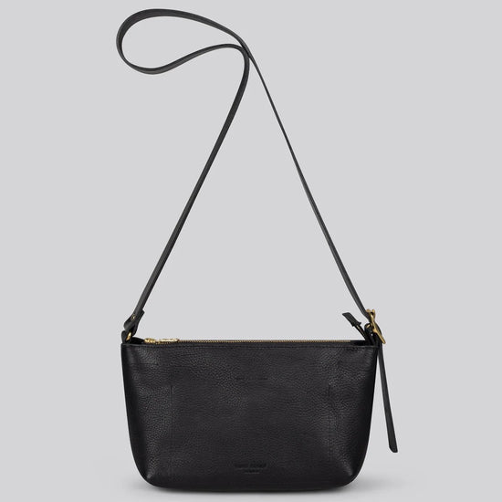 A black pebbled leather crossbody bag with a long shoulder strap and gold-tone hardware, shown against a solid light gray background.