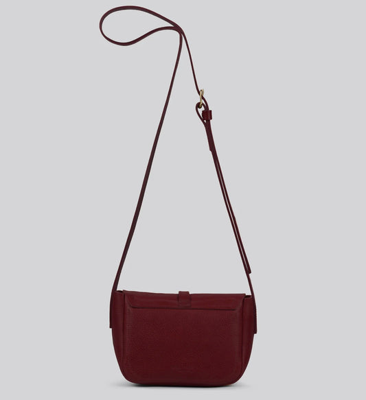 Maroon artisan leather shoulder bag with a strap on a light gray background