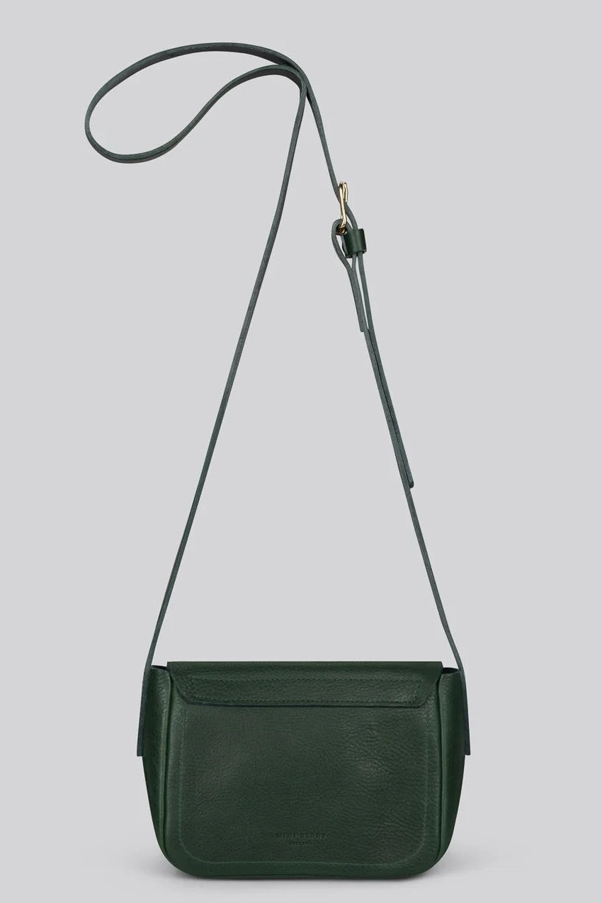 A dark green leather crossbody bag with a long adjustable strap, shown against a solid light gry background.