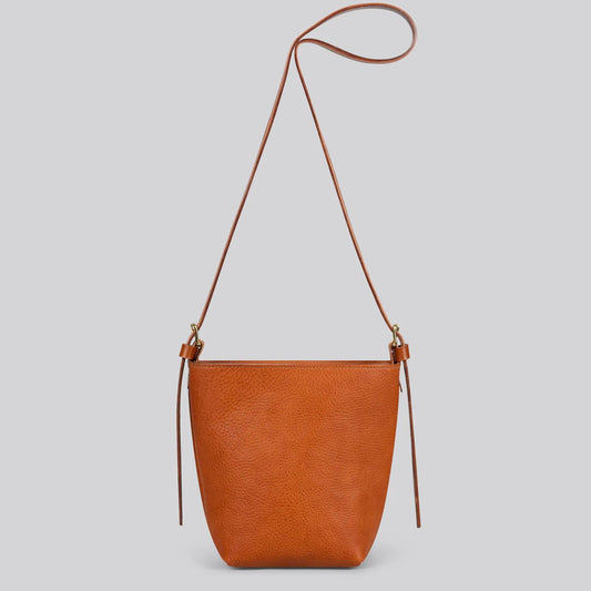 Brown tan leather shoulder bag on a light gray background