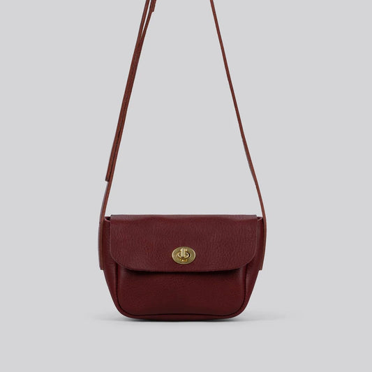 Maroon red leather crossbody bag with a gold clasp on a light gray background