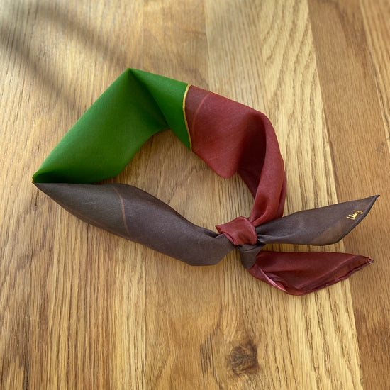 Three-colored  silk neck scarf on a wooden surface