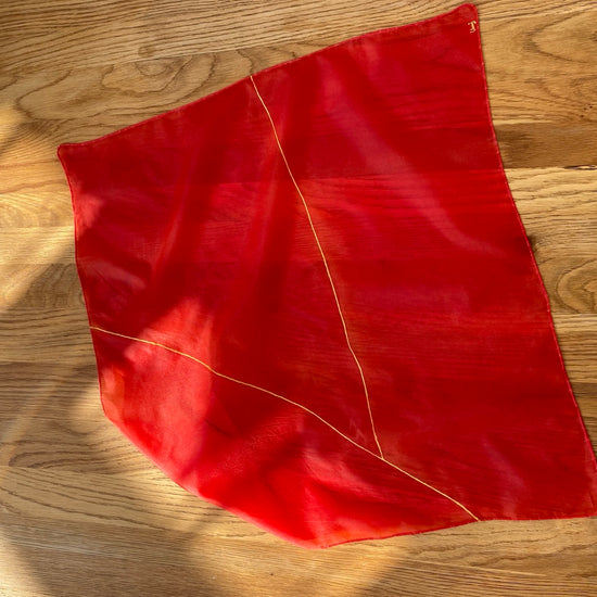 Red silk scarf on a wooden surface