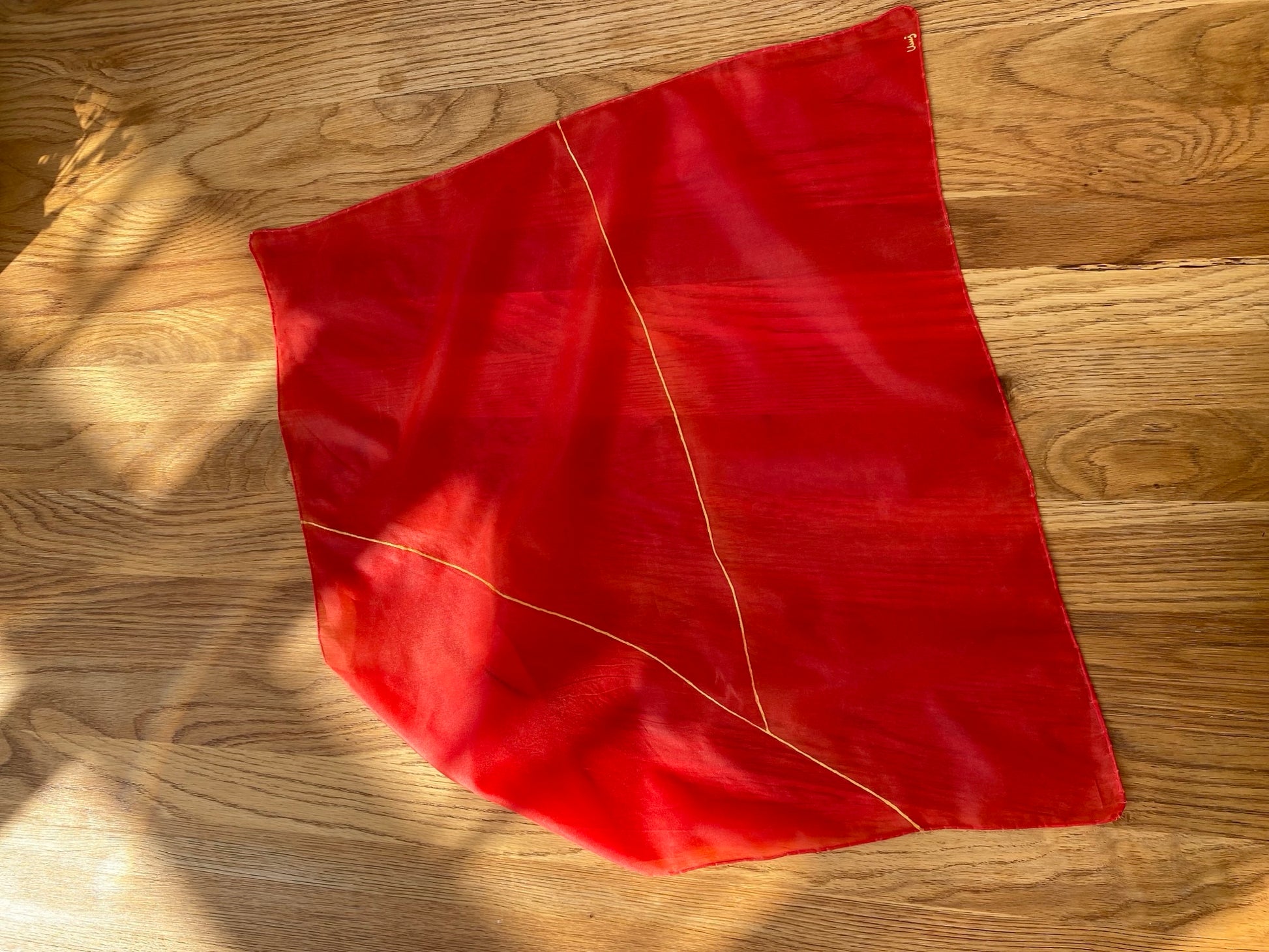 Red silk scarf on a wooden surface