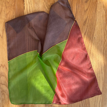 Multicolored fabric with brown, green, and red sections on a wooden surface