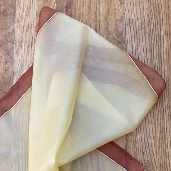 Folded fabric with brown and beige colors on a wooden surface