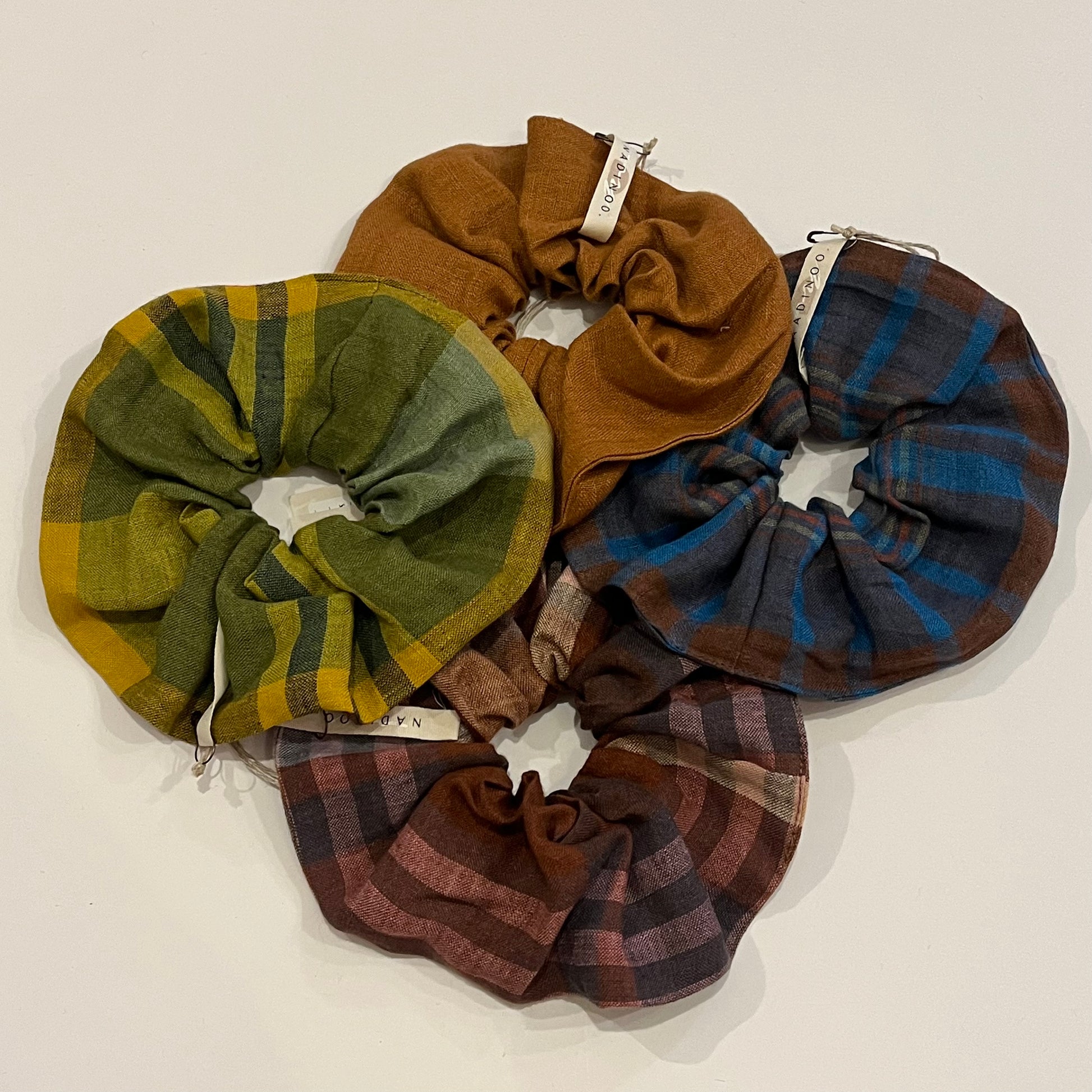 Set of plaid scrunchies in various colors on a white background