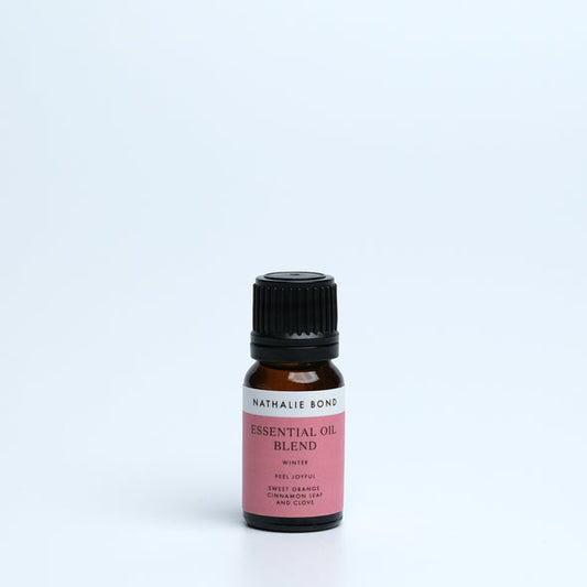 A bottle of Nathalie Bond Essential Oil Winter Blend with visible labeling, set against a plain background.