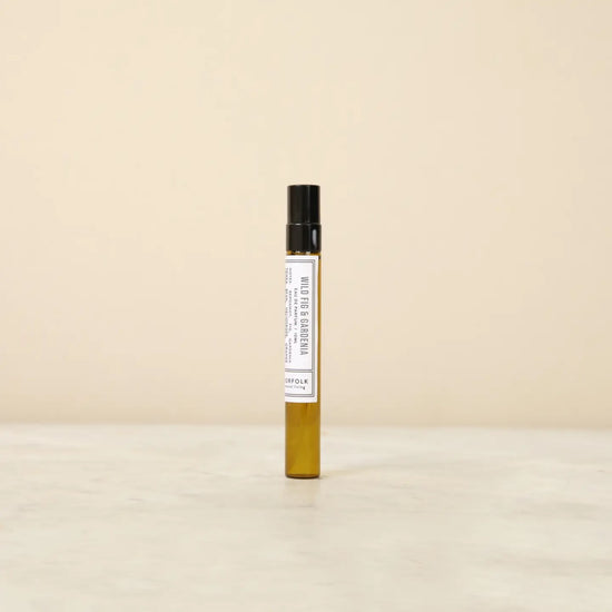 Small perfume bottle with a label on a beige background