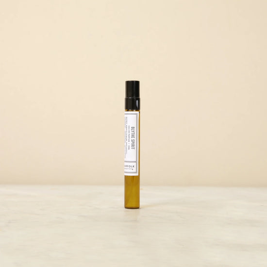 Small perfume bottle with a white label on a beige background